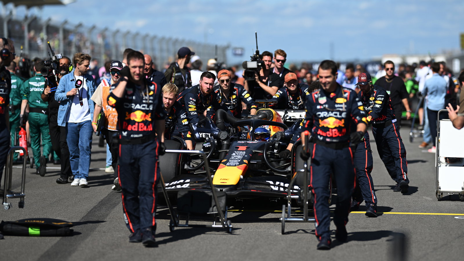 Red Bull crew wheel Max Verstappen onto the grid
