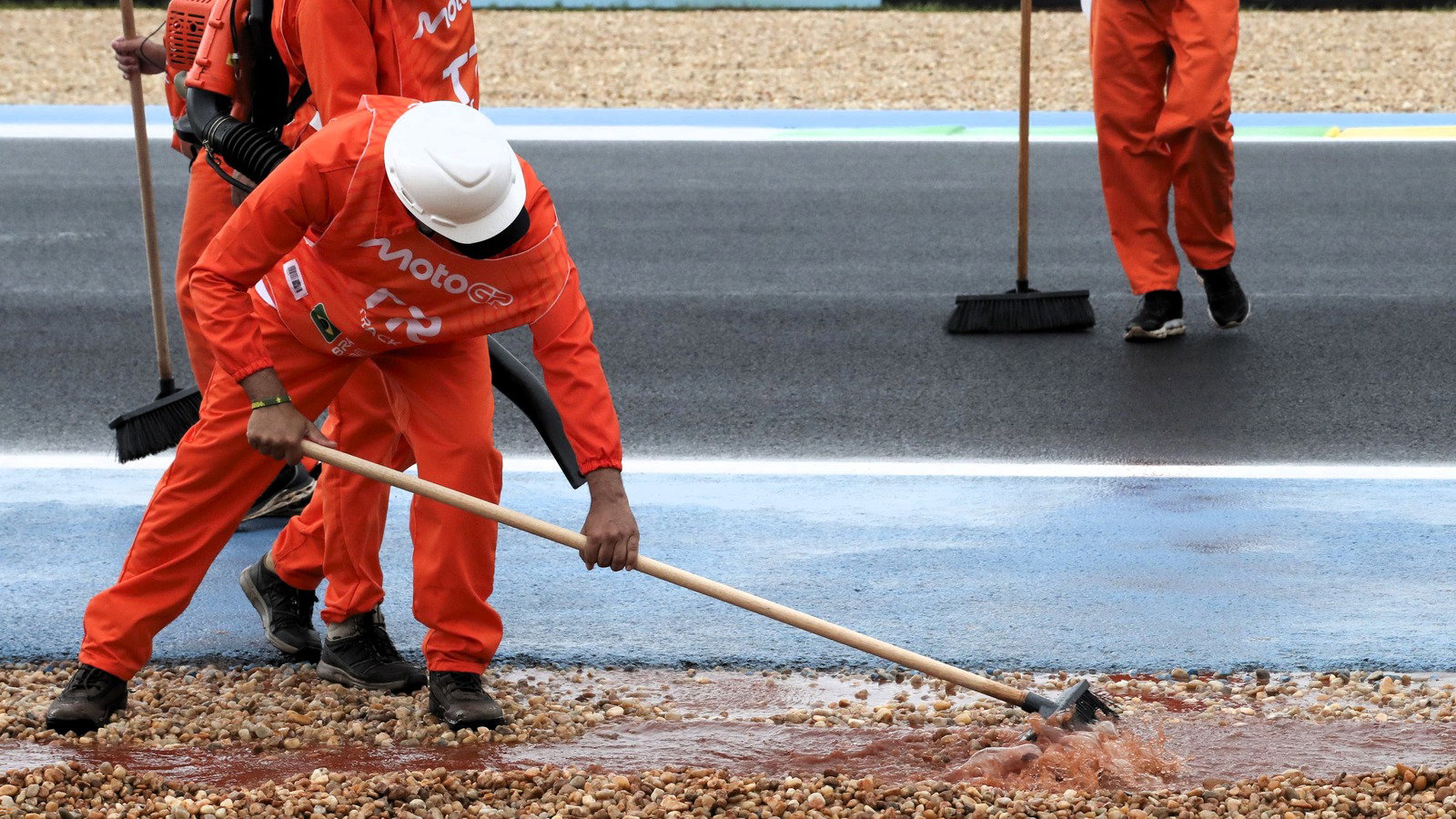 Marshals cleaning track during delayed Moto3 practice, Brazilian MotoGP, 20 March 2026