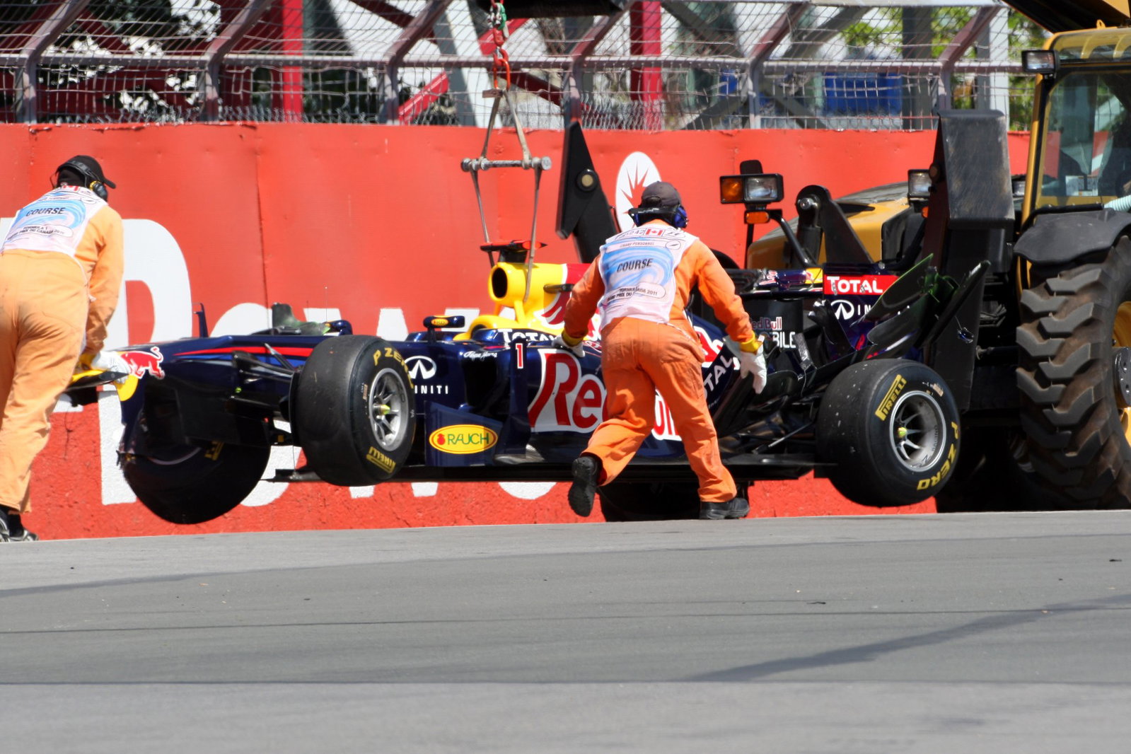 Sebastian Vettel's car is hauled away after hitting the Wall of Champions during practice in 2011