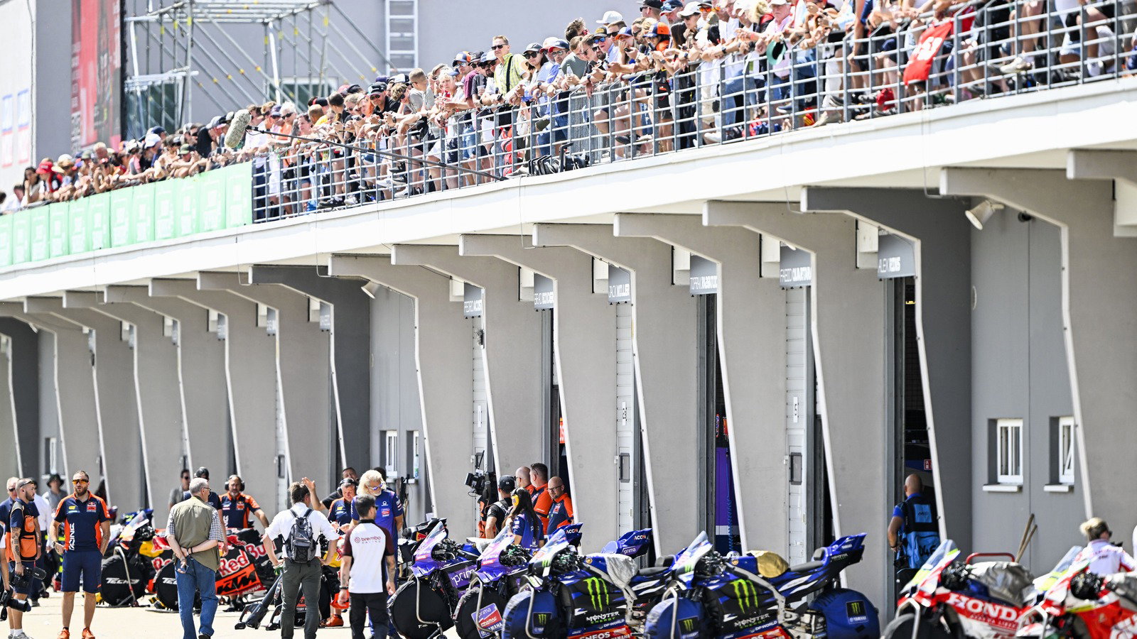 MotoGP bikes in pit lane.