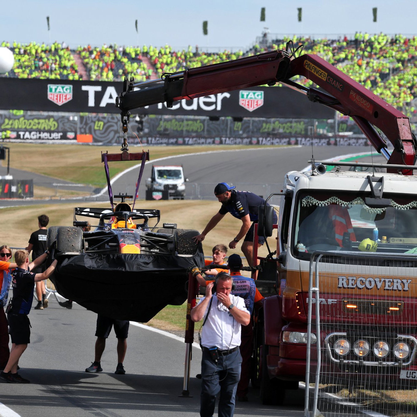 Verstappen's Red Bull is craned back to the pits