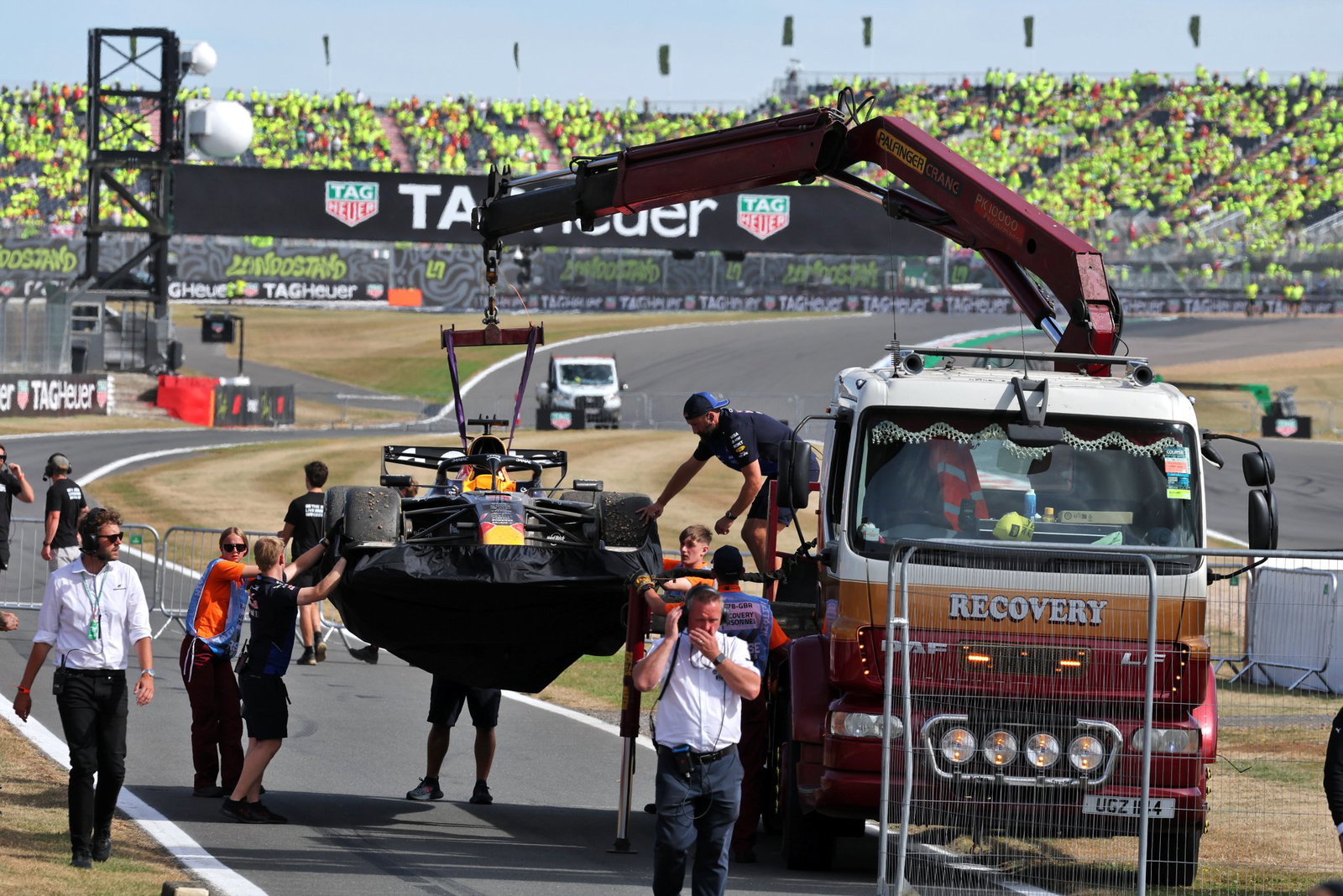 Verstappen's Red Bull is craned back to the pits