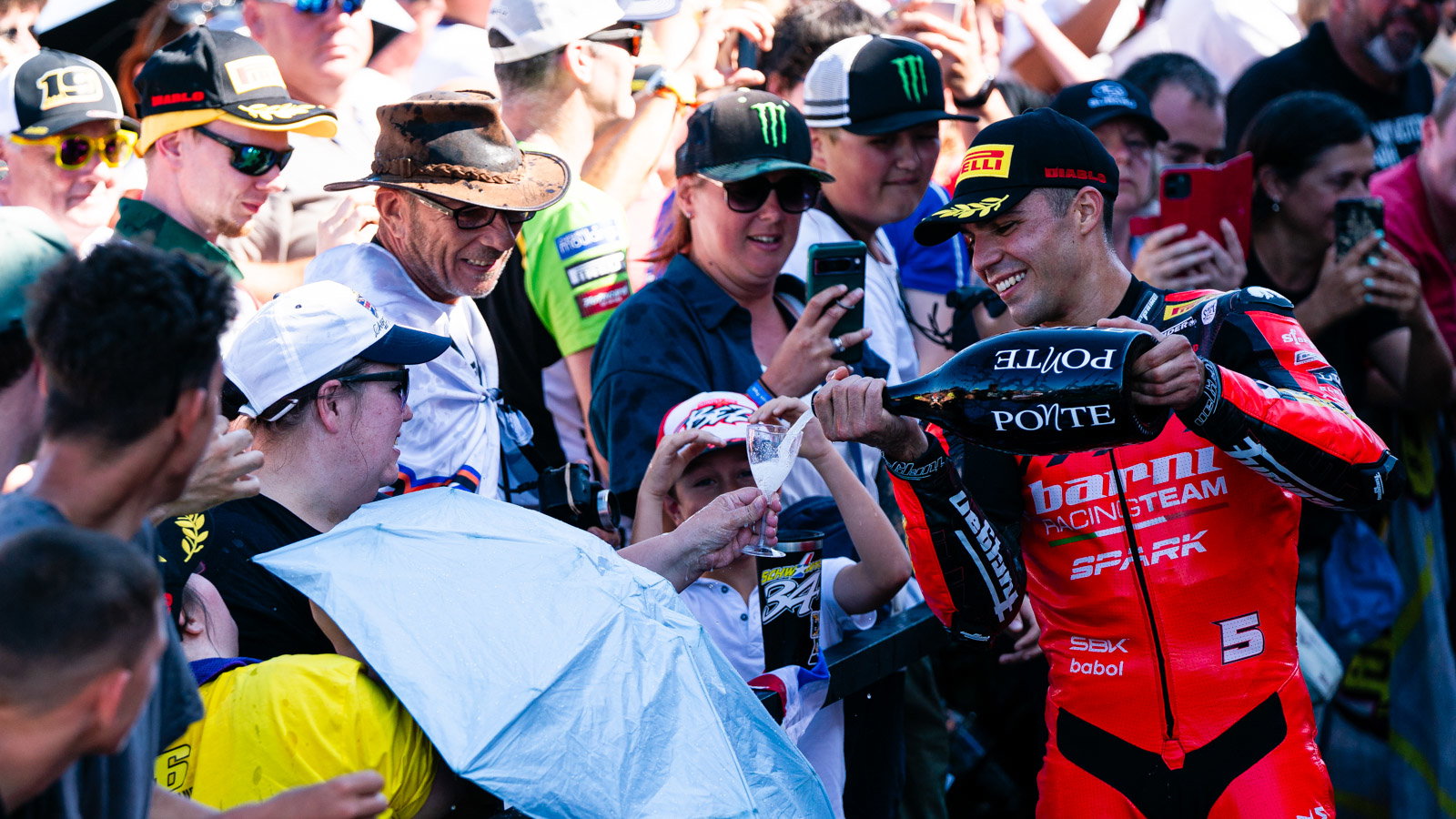 Yari Montella pours champagne for a fan, 2026 UK WorldSBK, podium. Credit: Tony Goldsmith.