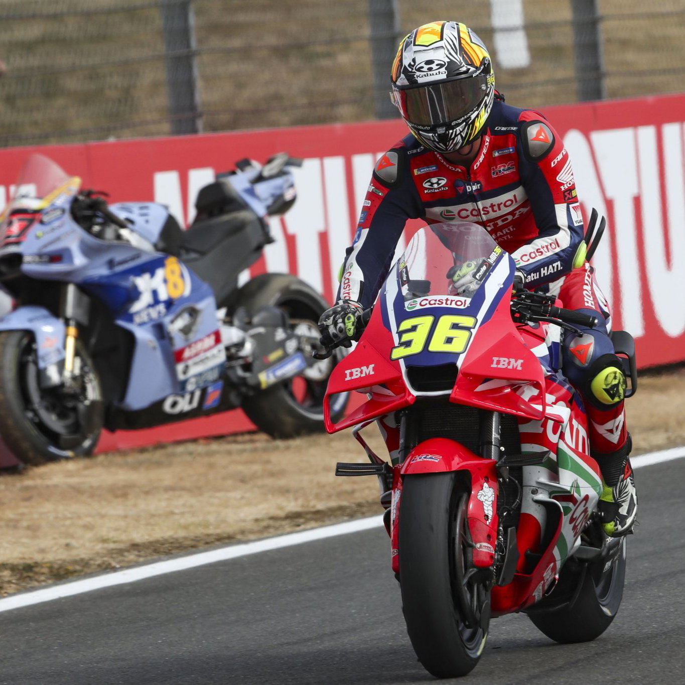 Joan Mir rides past Iker Lecuona's parked bike at Silverstone MotoGP. Credit: Gold and Goose.