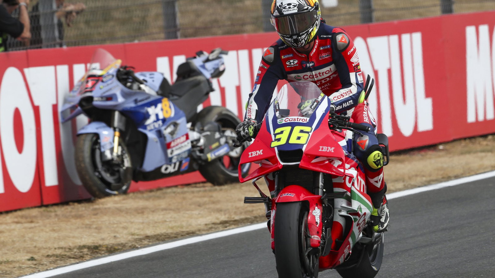 Joan Mir rides past Iker Lecuona's parked bike at Silverstone MotoGP. Credit: Gold and Goose.