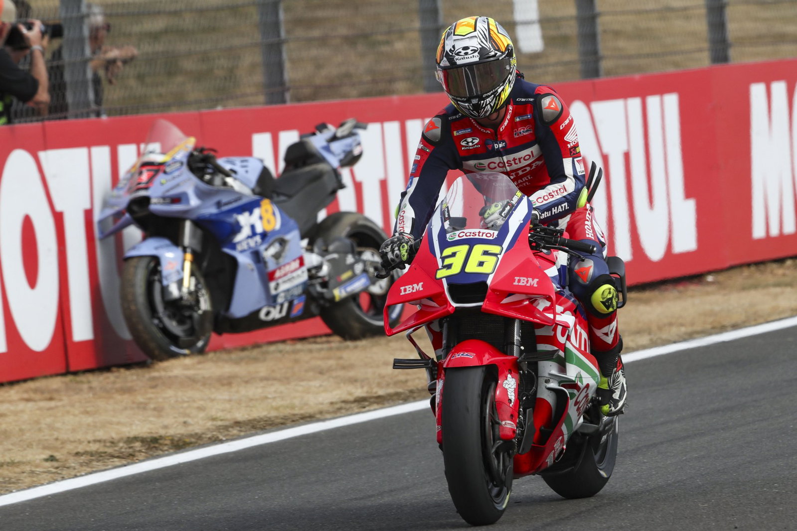 Joan Mir rides past Iker Lecuona's parked bike at Silverstone MotoGP. Credit: Gold and Goose.