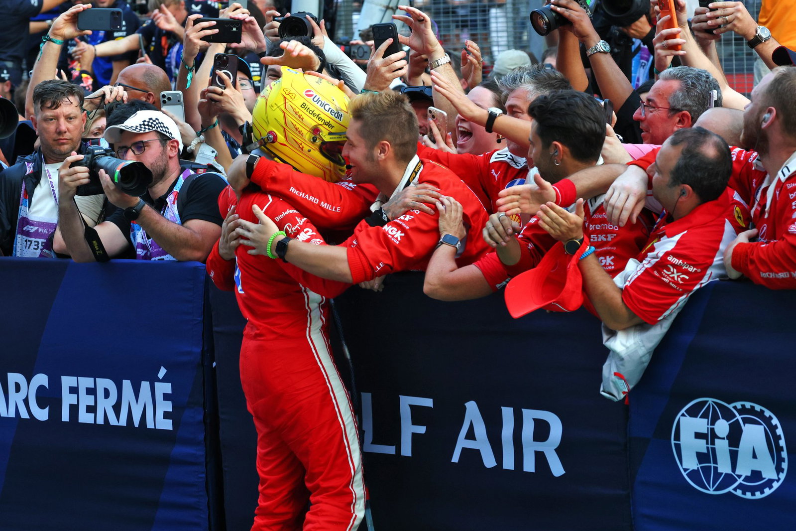 Hamilton celebrates with his Ferrari crew in parc ferme