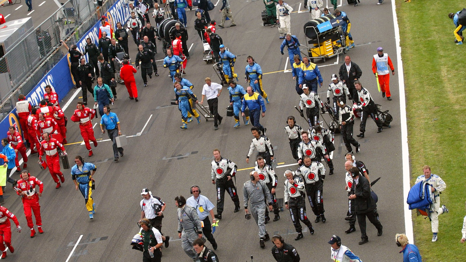 The mechanics and team pertsonnel return to the pit lane after the cars depart on their parade lap a