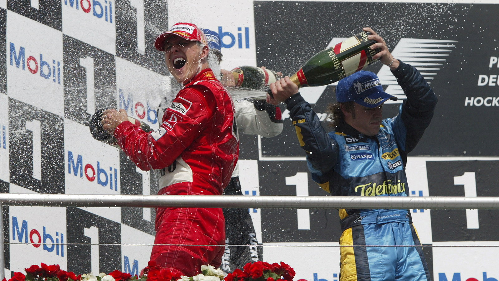 Jenson Button, Fernando Alonso and Michael Schumacher celebrate on the podium