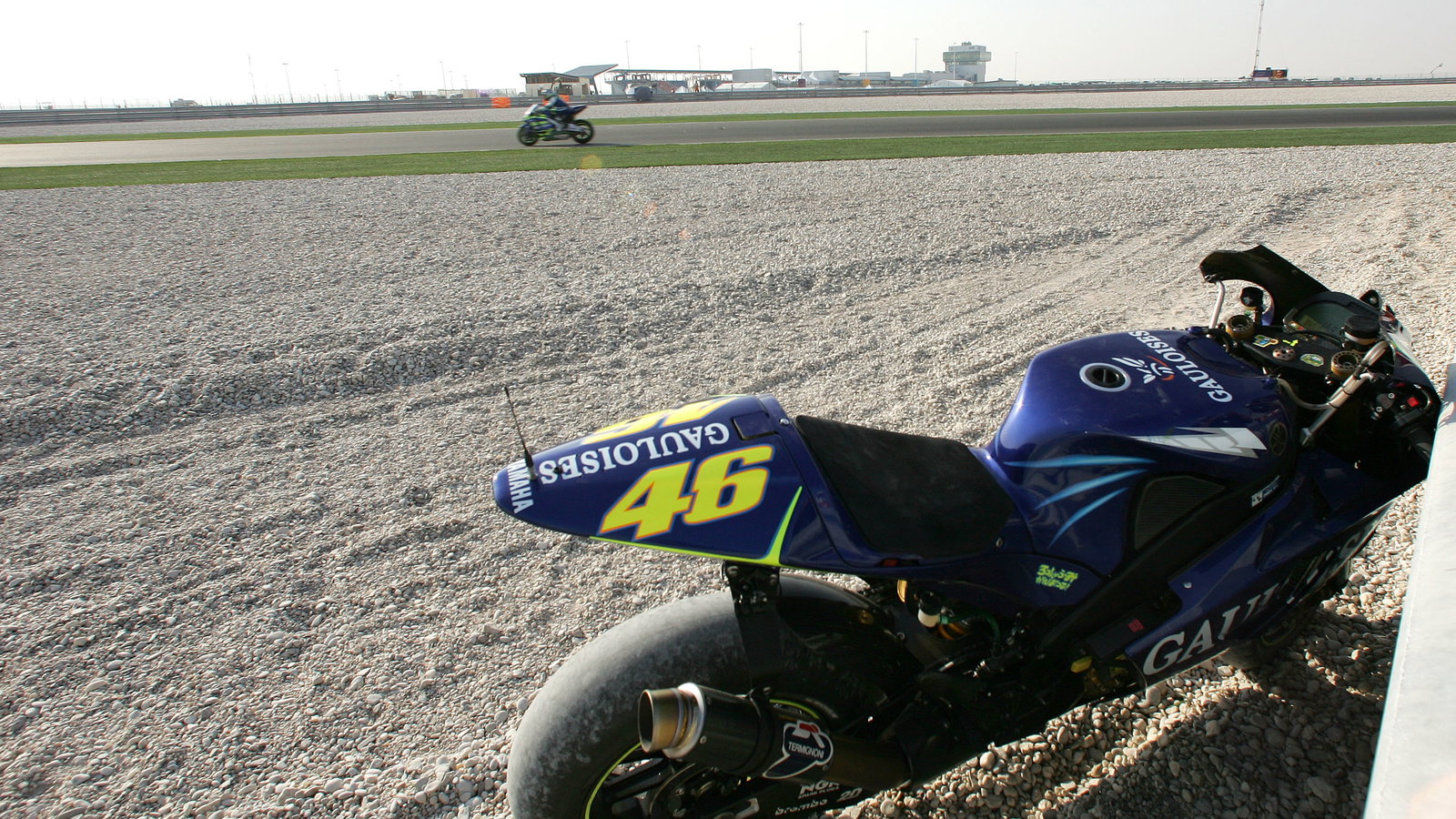 Gibernau rides past Rossi`s crashed Yamaha, Qatar MotoGP, 2004