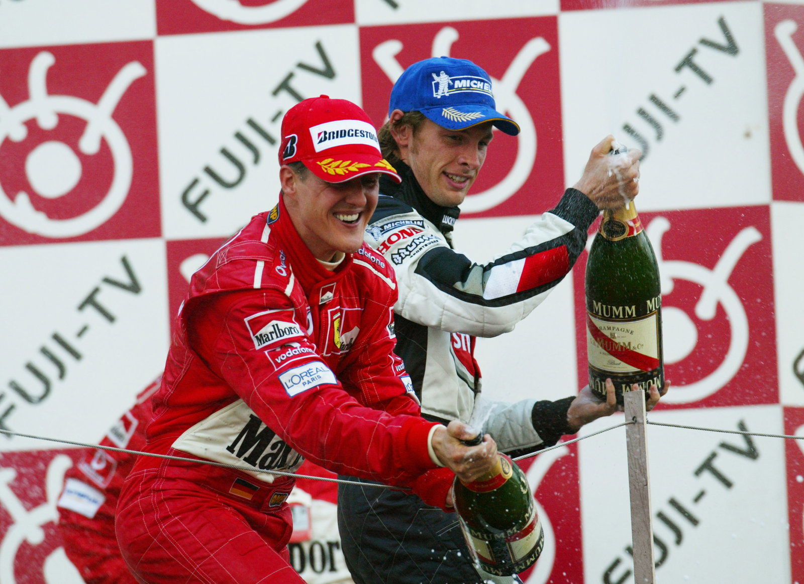 Michael Schumacher and Jenson Button celebrate after the Japanese Grand Prix