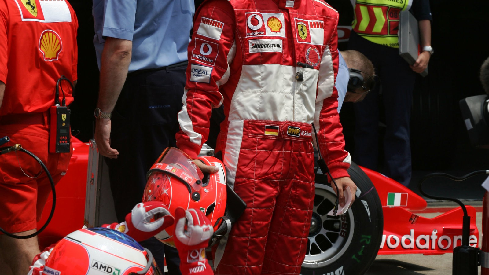 Michael Schumacher waits for Rubens Barrichello after the Brazilian`s qualifying lap was aborted by