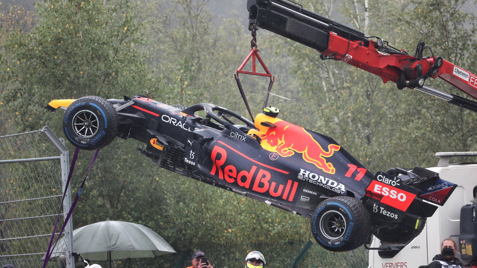The Red Bull Racing RB16B of Sergio Perez (MEX) is craned away from the circuit after he crashed heading to the grid.